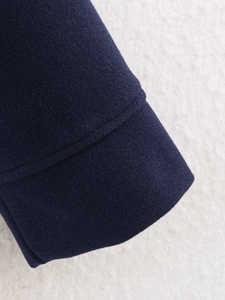 Detailed close-up of navy wool coat cuff showing premium double stitching and texture