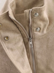 Close-up of khaki suede jacket collar with silver metal zipper and snap button details