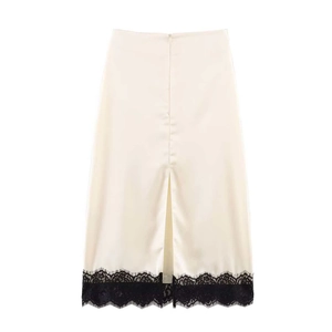 Gros plan détaillé d'une jupe mi-longue en satin crème avec dentelle noire raffinée