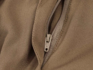 Macro shot of silver metal zipper detail on brown twill fabric for casual midi skirt