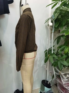 Detail view of brown and black plaid shirt with adjustable drawstring hem on a mannequin