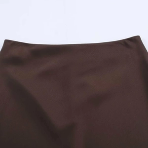 Détail macro de la taille d'une jupe en satin marron avec texture de tissu fine