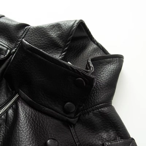 Close-up of black faux leather jacket featuring stand collar and pebble grain texture