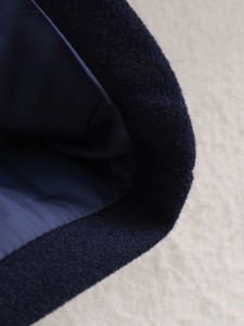 Detail of navy wool blend jacket showing textured fabric and light blue smooth lining