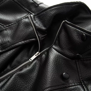 Detail of black faux leather jacket showing grain texture, metal zipper and snap buttons