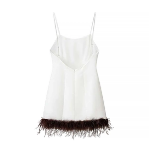 White mini dress with spaghetti straps and brown feather trim on the hem, back view