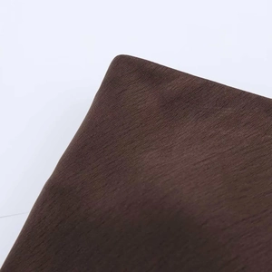 Vue macro détaillée de la texture du satin marron foncé montrant des plis et des fibres