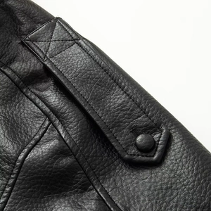 Detail of shoulder epaulet and fine stitching on high-quality black faux leather jacket