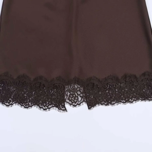 Gros plan sur l'ourlet en satin marron avec bordure en dentelle noire délicate