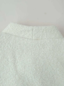Close-up detail of white faux shearling texture and collar stitching on the warm jacket