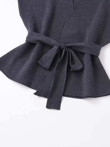 Détail du haut sans manches en maille gris anthracite avec ceinture nouée et bas volanté