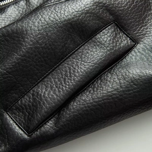 Macro shot of high-quality black faux leather texture with metal zipper and pocket detail
