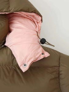 Detailed close-up of olive green winter jacket hood with pink lining and drawstring