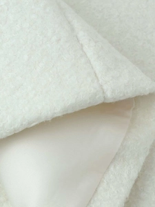 Detailed macro view of white sherpa wool texture and smooth inner silk lining seam