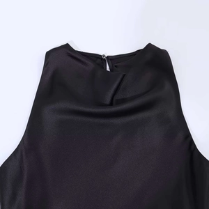 Dettaglio del top nero senza maniche in raso con scollo a drappeggio e bottone sul retro