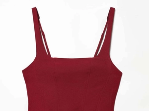 Detail of dark red satin dress showing adjustable spaghetti straps and square neckline