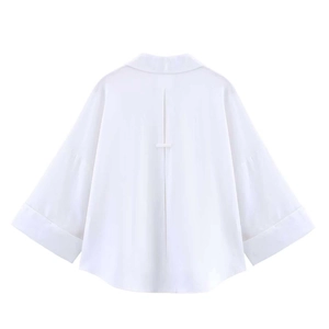 Detail view of the back pleat and horizontal strap on a white short-sleeve shirt
