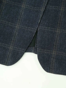Detail view of the back vent and plaid pattern on a navy blue vintage blazer