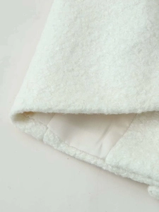 Close-up of white fleece wool fabric with smooth satin lining and premium stitching