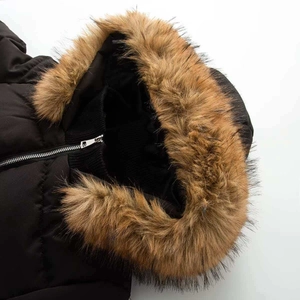 Détail de parka d'hiver avec col en maille noire et bordure en fausse fourrure marron