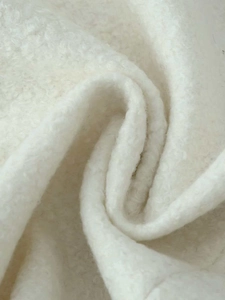 Macro shot of high-quality cream white sherpa fleece fabric showing thick curly texture