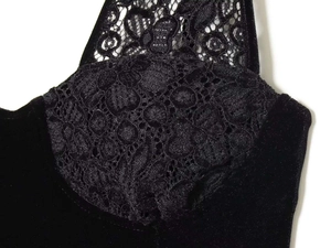 Détail de la robe en velours noir avec dentelle florale raffinée sur l'encolure en V