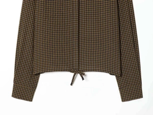 Detail view of brown gingham shirt featuring drawstring hem and buttoned sleeve cuffs