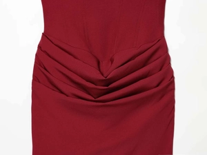 Detail of burgundy satin dress showing elegant ruched waist design and structured seams