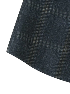 Close-up of deep blue vintage plaid fabric texture showing fine weave on the blazer hem