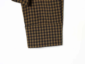 Detailed view of the brown and black gingham fabric texture with clean stitched hemline