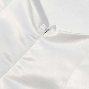 Close-up of invisible zipper detail on white satin dress with smooth silky texture
