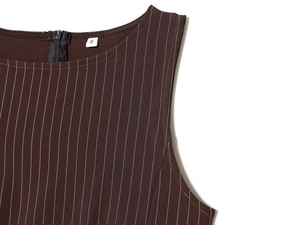 Détail de l'encolure et du zip invisible sur une robe marron à fines rayures