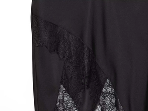 Detail von eleganter schwarzer Spitzen-Patchwork und zartem Wimpern-Fransen-Saum am Rock