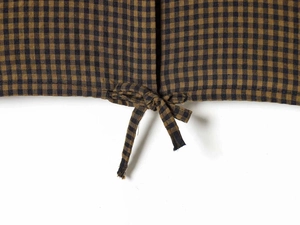 Close-up of brown and black plaid shirt hem with decorative drawstring tie details