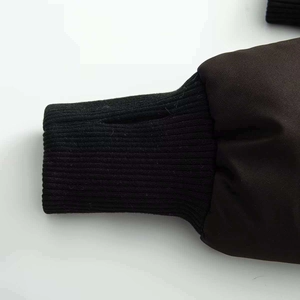 Détail de la veste d'hiver noire avec poignets côtelés et trous pour les pouces