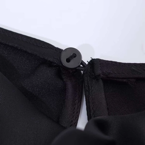 Dettaglio della chiusura posteriore del colletto con bottone nero e asola elastica