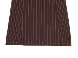 Détail du tissu à rayures marron foncé montrant l'ourlet à double couture et la texture