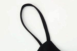Close-up of thin spaghetti straps and stitching on a black V-neck summer dress