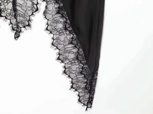 Detail der zarten schwarzen Wimpernspitze am Saum eines eleganten asymmetrischen Rocks