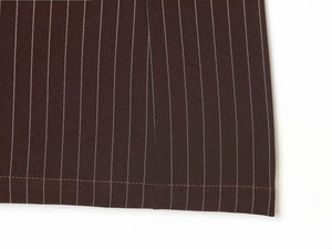 Détail des fines rayures blanches sur tissu de robe marron foncé et couture précise