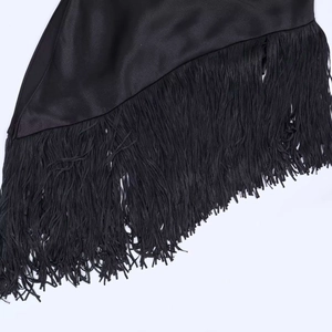 Dettaglio dell'orlo in raso nero con lunghe frange decorative e finitura lucida