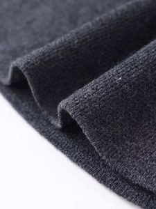 Gros plan sur un tricot gris foncé montrant la texture douce de laine et la maille fine