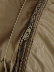 Detail of a dark olive puffer jacket featuring a nylon zipper and smooth technical fabric