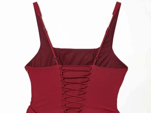 Detail of red satin dress featuring adjustable spaghetti straps and corset lace-up back design