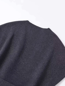 Détail de la texture de la maille tricotée gris foncé sur un pull élégant avec lien
