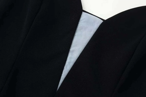 Detailed close-up of the sexy V-neckline with light blue sheer mesh stitching on black dress
