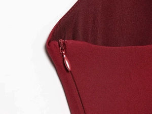 Detailed close-up of the hidden zipper on this burgundy satin fishtail dress