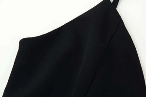 Detailed close-up of thin black spaghetti straps and V-neckline stitching of the summer dress