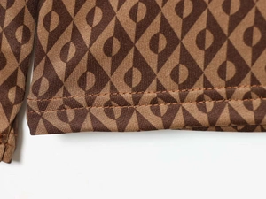 Détail du tissu en maille marron à motif géométrique et coutures doubles précises