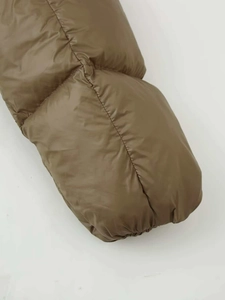 Detail view of olive green quilted puffer jacket featuring water-resistant fabric texture
